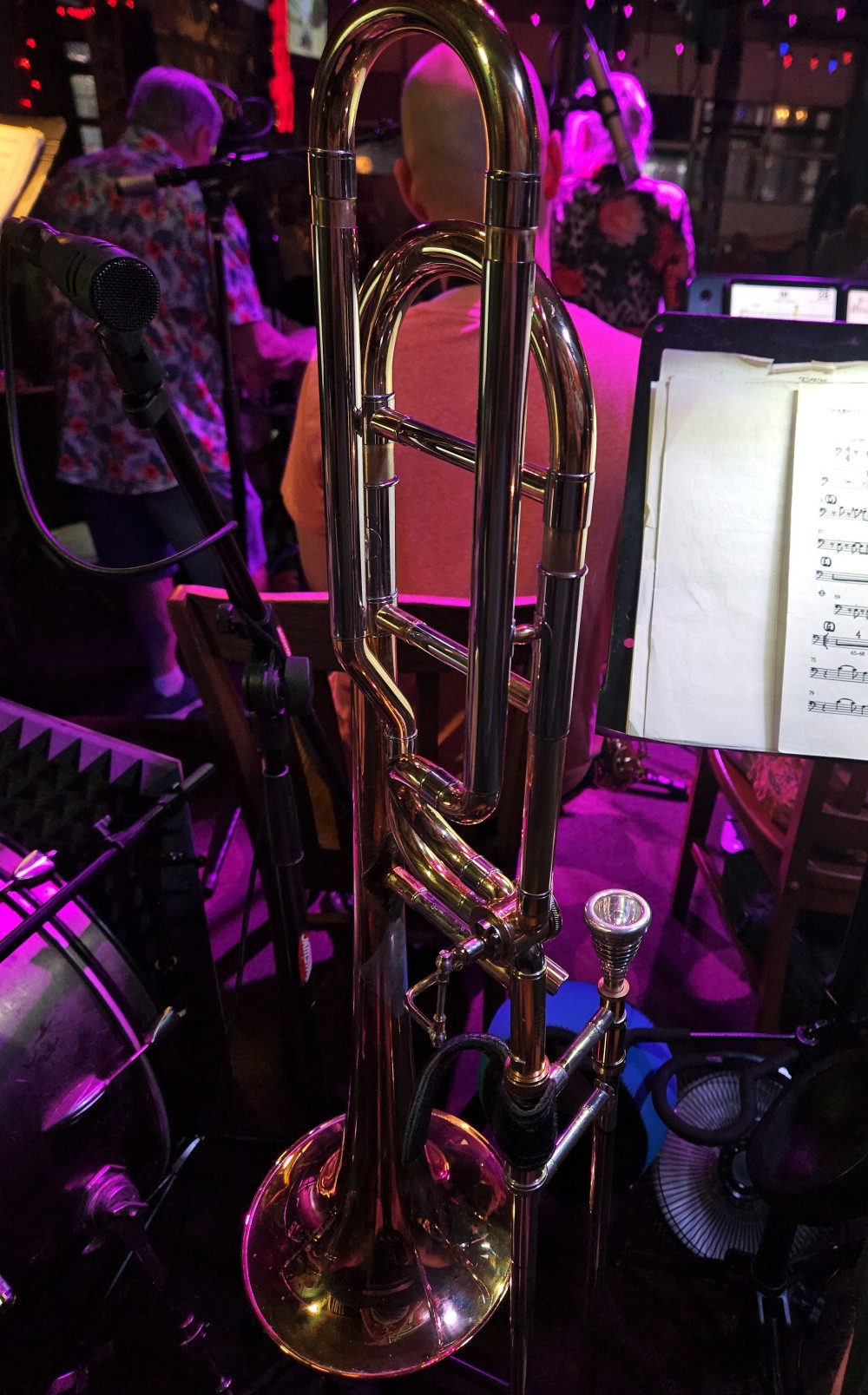 Trombone on stand with stage lighting and music sheets